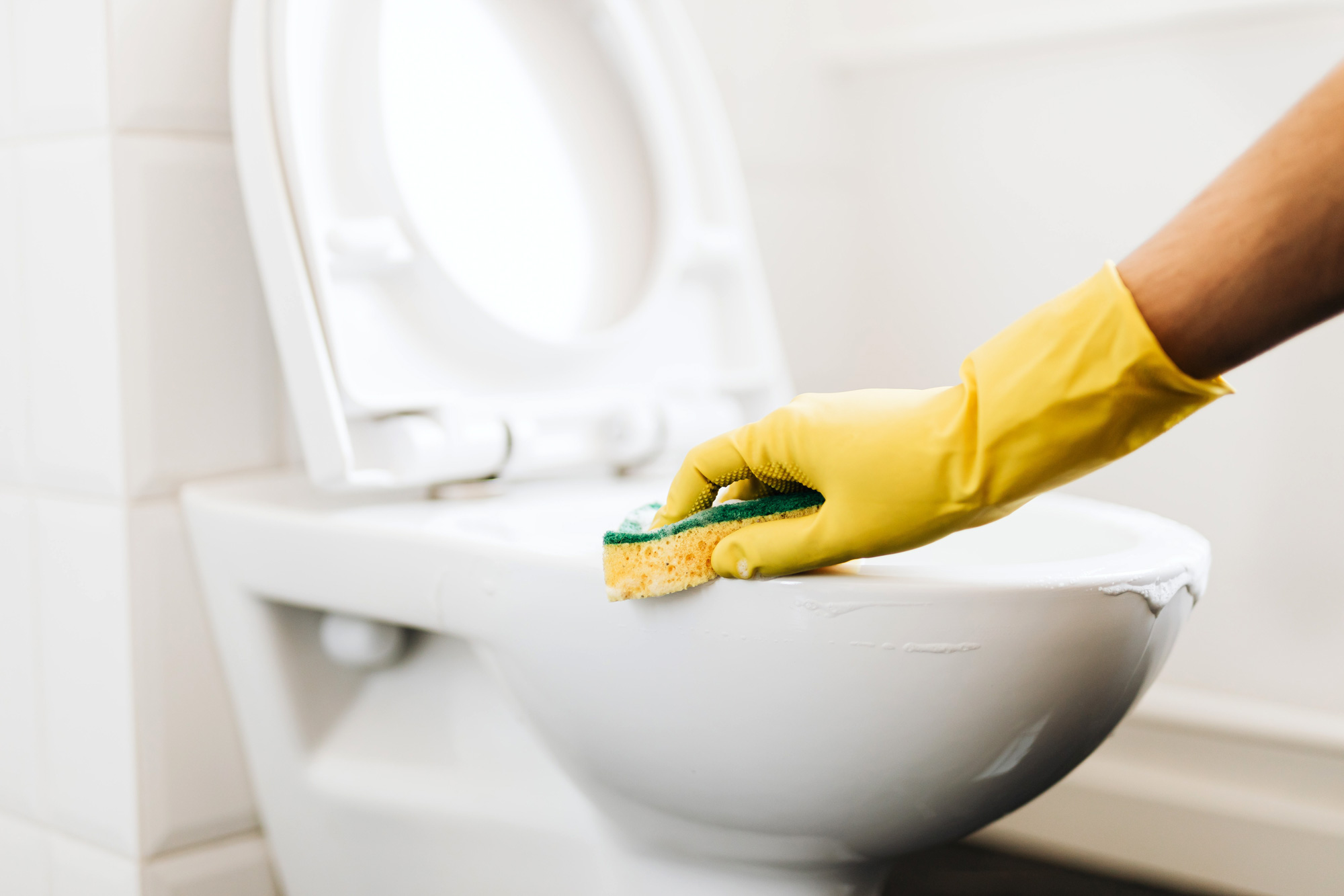 Scrubbing bathroom with cleaning gloves Photography by karolina grabowska pexels